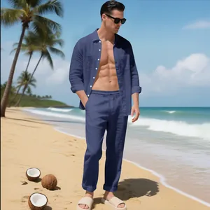 Zweiteiliger blauer Leinenanzug für Herren, präsentiert an einem sonnigen Strand.