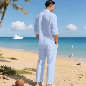 Rückansicht eines Mannes in einem hellblauen Leinen-Set an einem sonnigen Strand