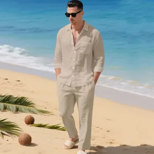 Lifestyle-Ansicht eines beigen Herren-Leinen-Sets an einem sonnigen sommerlichen Strand.