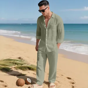 Lässiges, salbeigrünes Leinenset für Herren, Langarmhemd und passende Hose am Strand.