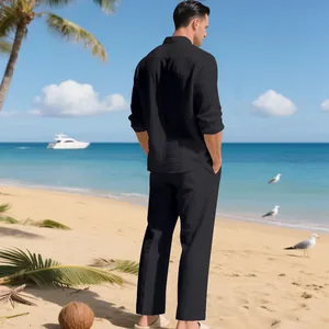 Modisches Herren-Set aus schwarzem Leinenhemd und langer Hose Rückansicht am Strand