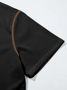 Macro view of pineapple grid fabric and contrast stitching on black polo shirt sleeve