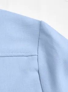 Detailed macro view of light blue breathable linen-textured fabric on men's casual shirt