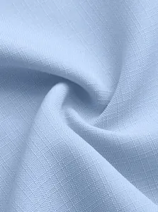 Macro shot of light blue breathable linen fabric showing fine texture and weave