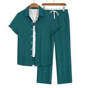 Detail of men's dark teal pleated two-piece set featuring short sleeve shirt and trousers