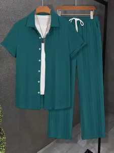 Detail view of men's pleated short sleeve shirt and matching long pants set in teal