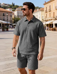 Male model wearing grey textured jacquard polo shirt and matching shorts set outdoors