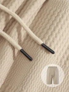 Close-up view of beige textured jacquard fabric and drawstring detail on men's casual shorts