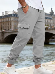 Dettaglio dei pantaloni sportivi cargo in pile grigio da uomo con multitasche e coulisse in vita
