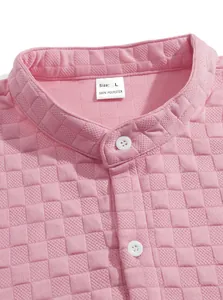Detailed macro view of a pink jacquard loungewear shirt collar showing buttons and size tag