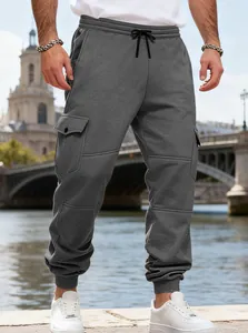 Dettaglio dei pantaloni cargo in pile grigio scuro da uomo con coulisse e tasche multiple