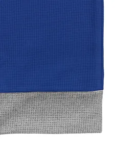 Gros plan sur la texture du tissu en maille gaufrée bleue et grise d'un polo homme