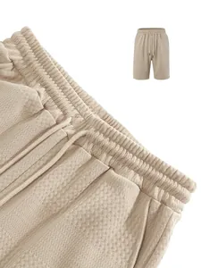 Detailed close-up of beige textured waffle knit shorts featuring a drawstring elastic waistband