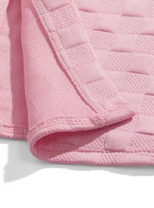 Close-up of pink jacquard fabric texture and hem detail on mens loungewear