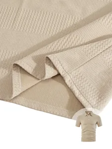 Gros plan sur la texture du tissu jacquard et l'ourlet d'un polo beige pour homme.