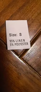 Close-up of garment tag showing 95% linen and 5% polyester blend material