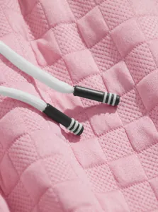 Macro view of pink jacquard fabric texture and white drawstring detailing