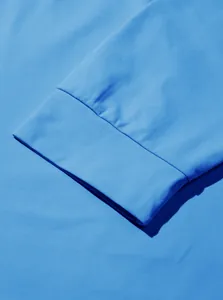 Dettaglio macro del polsino in maglia elastica celeste che mostra la trama del tessuto