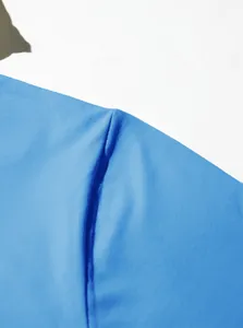 Primo piano delle cuciture di qualità e del tessuto in maglia blu di una felpa sportiva da uomo