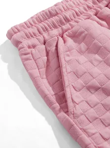 Close-up detail of pink men's casual shorts featuring a textured jacquard diamond pattern