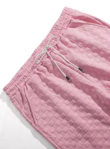 Close-up detail of pink men's casual shorts showing jacquard waffle texture and drawstring.