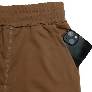 Vista dettagliata della tasca dei pantaloncini sportivi marroni con spazio telefono