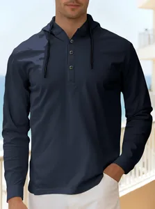 Primo piano di felpa con cappuccio Henley blu scuro da uomo in un ambiente esterno.