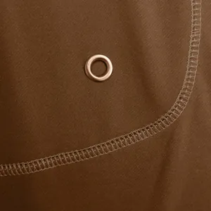 Dettaglio del tessuto twill marrone con occhiello metallico sulla polo sportiva uomo