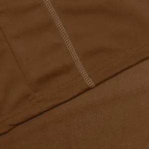 Primo piano dei dettagli delle cuciture della polo marrone e trama del tessuto twill