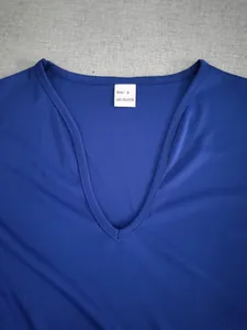 Détail d'un débardeur bleu à col en V avec étiquette de composition 100% polyester.