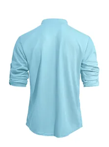 Back view of a light blue waffle knit Henley shirt featuring adjustable roll-up sleeves.