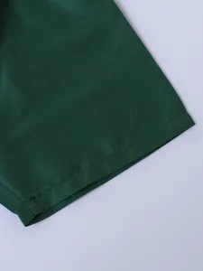 Dettaglio delle cuciture di alta qualità sulla manica della camicia verde da bambino