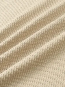 Primer plano de la textura del tejido de nido de abeja beige de una camiseta de hombre