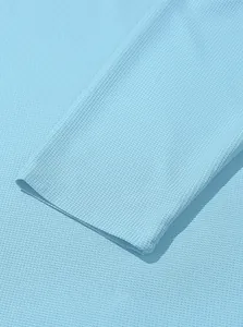 Detailed macro shot of light blue waffle knit texture and cuff stitching on a men's top.