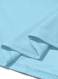 Close-up detail of light blue waffle knit fabric showing texture and stitching.
