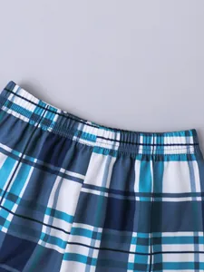 Primer plano detallado de la cintura elástica y la tela de cuadros azules del pantalón.