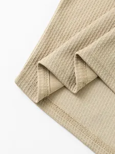 Vista macro detallada de la textura acanalada y la costura del dobladillo de camiseta beige