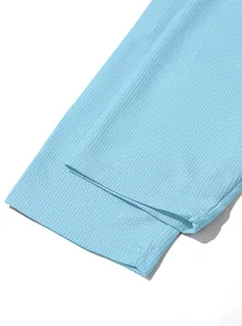 Close-up detail of light blue waffle knit fabric on mens casual long sleeve shirt cuff