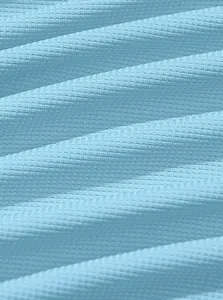 Close-up macro view of light blue waffle knit fabric showing detailed breathable texture