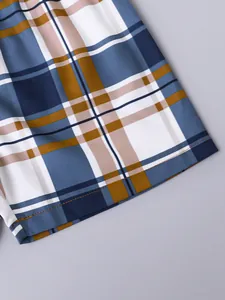 Close-up of neat stitching and blue plaid pattern on boys' breathable cotton shorts