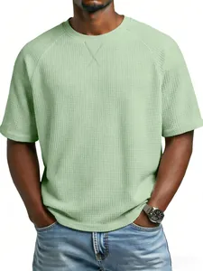 Detalle de la camiseta raglán para hombre de punto gofrado en verde pálido con textura.