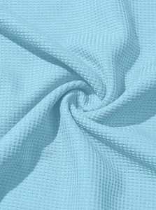 Macro detail of breathable light blue waffle knit fabric texture for men's casual shirt