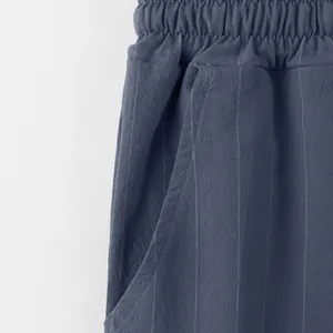 Detailed macro shot of blue linen striped beach pants showing waistband and pocket
