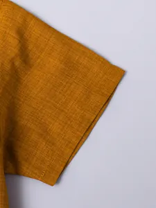 Macro view of mustard yellow breathable linen fabric on boys' short sleeve shirt
