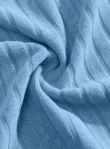 Detaillierte Makroansicht der hellblauen, weichen Jacquard-Stoffstruktur für Bademäntel