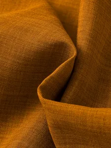 Close-up of the breathable mustard brown woven fabric texture for boys' summer outfit