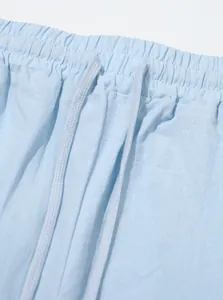Detailed macro view of light blue men's linen pants waistband with elastic and drawstring