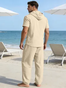 Rückenansicht eines beige Leinen-Set für Herren mit Kapuzenhemd und Hose am Strand
