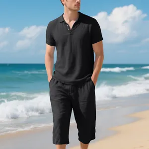 Vue détaillée de l'ensemble polo et pantalon en lin noir pour homme porté sur une plage