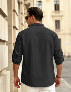 Rear view of men's black waffle knit shirt with roll-up sleeves in street setting.
